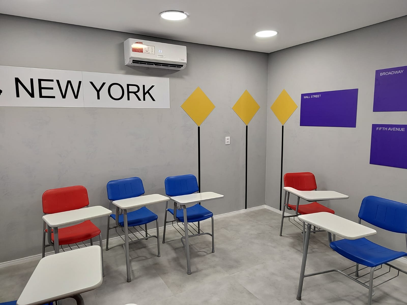 Sala de aula temática New York, com placa da cidade, losangos amarelos e painéis roxos de ruas